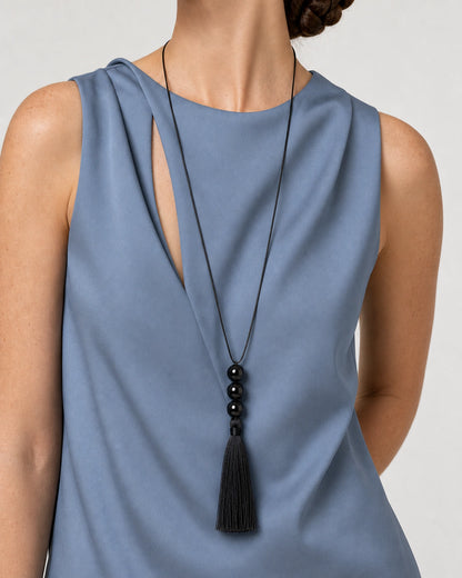 Left three-quarter neck-to-torso pose wearing the Nera three-bead tassel necklace