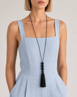 Close wearing view of the Nera three glossy beads and complete black tassel