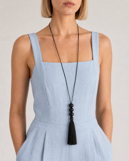 Close wearing view of the Nera three glossy beads and complete black tassel