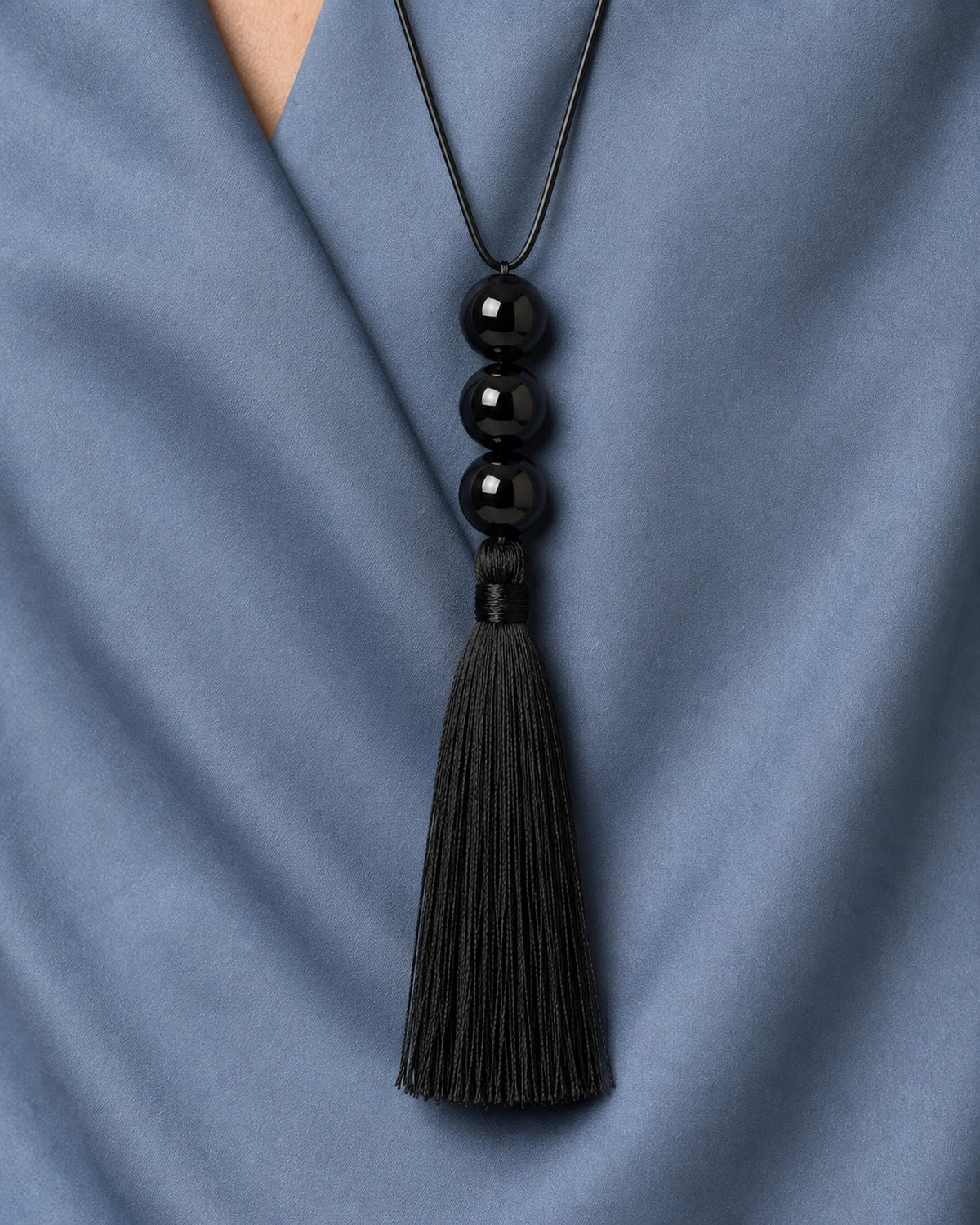 Complete worn macro of the Nera three beads, wrapped neck and full black tassel