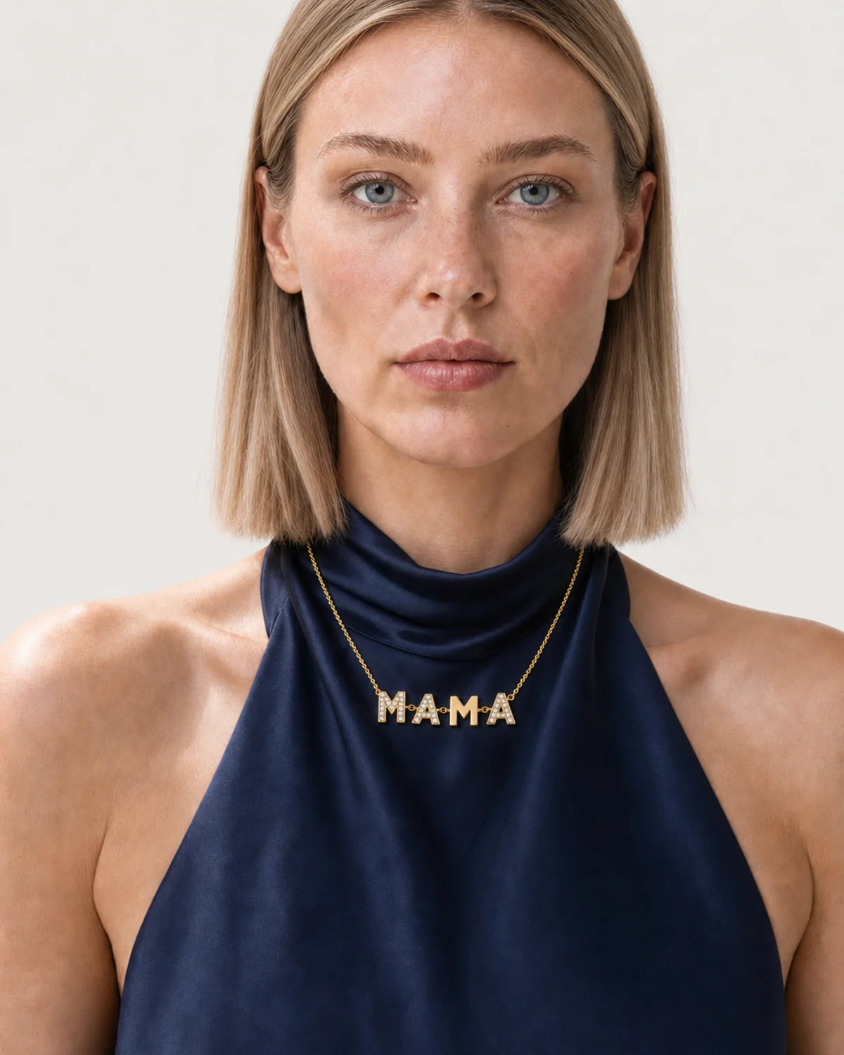 British model aged 25 to 28 wearing the Noa Articulated Mama Necklace in a pale dove-grey studio