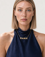 British model aged 25 to 28 wearing the Noa Articulated Mama Necklace in a pale dove-grey studio