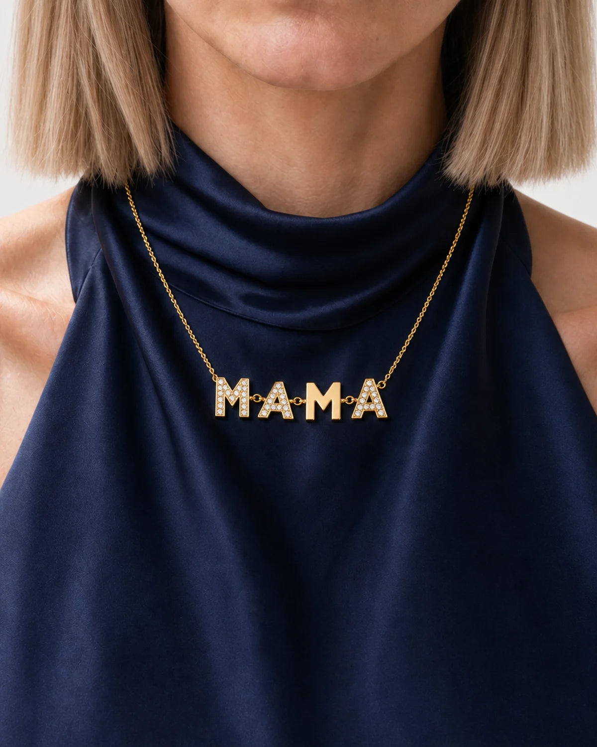 Clean neckline close-up of the Noa articulated block-letter MAMA necklace