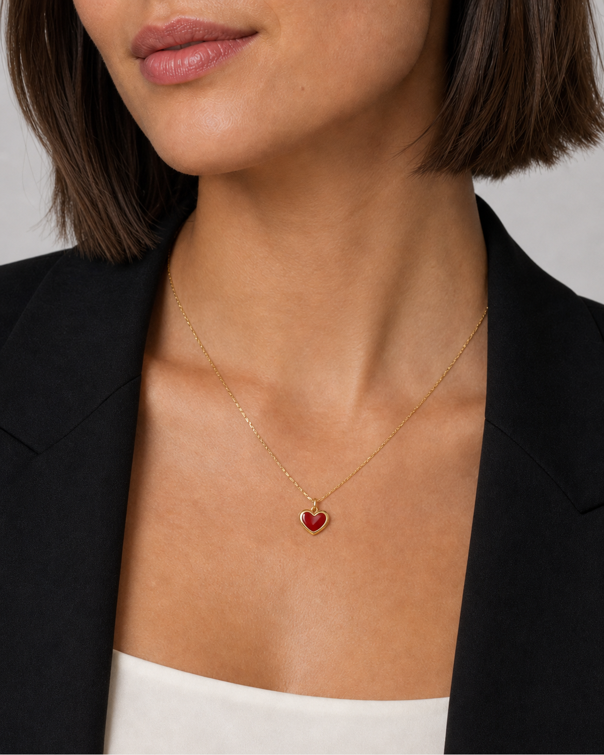 Close neckline view of the petite Noémie crimson heart and fine gold chain