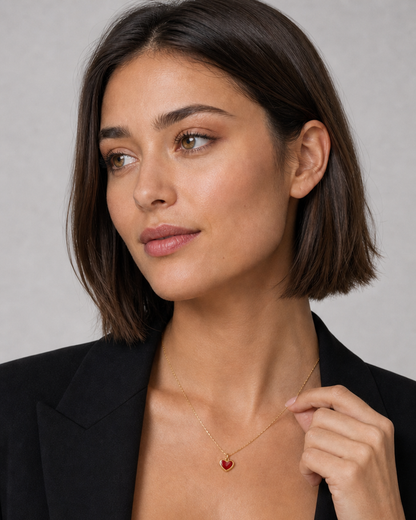 Human-scale wearing detail of the Noémie gold crimson heart necklace