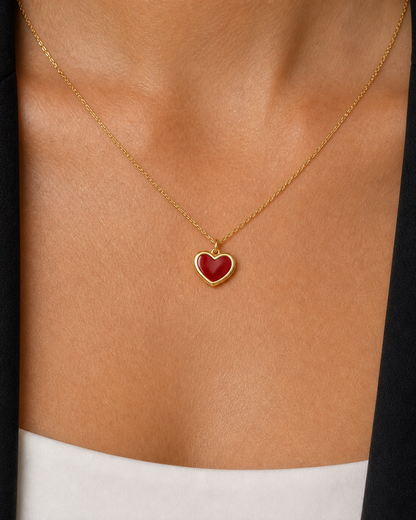 Extreme on-body macro of the Noémie raised gold rim and glossy crimson heart