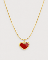 Macro of the Noemie glossy crimson heart, raised gold rim and fine bar-link chain