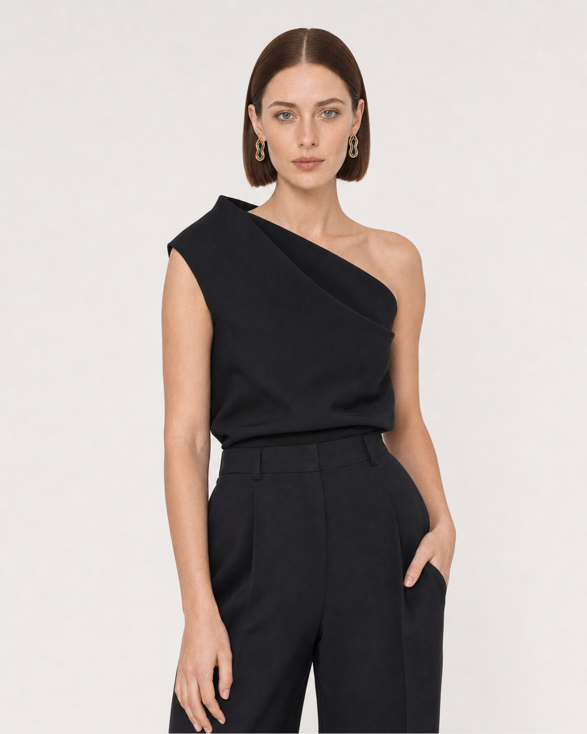 Human-scale studio view of the Nysa earrings with black tailoring