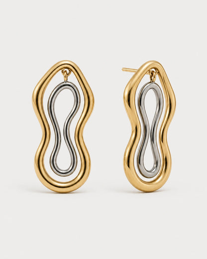 Pair of Nysa gold and silver sculptural figure-eight studs on seamless pale dove-grey