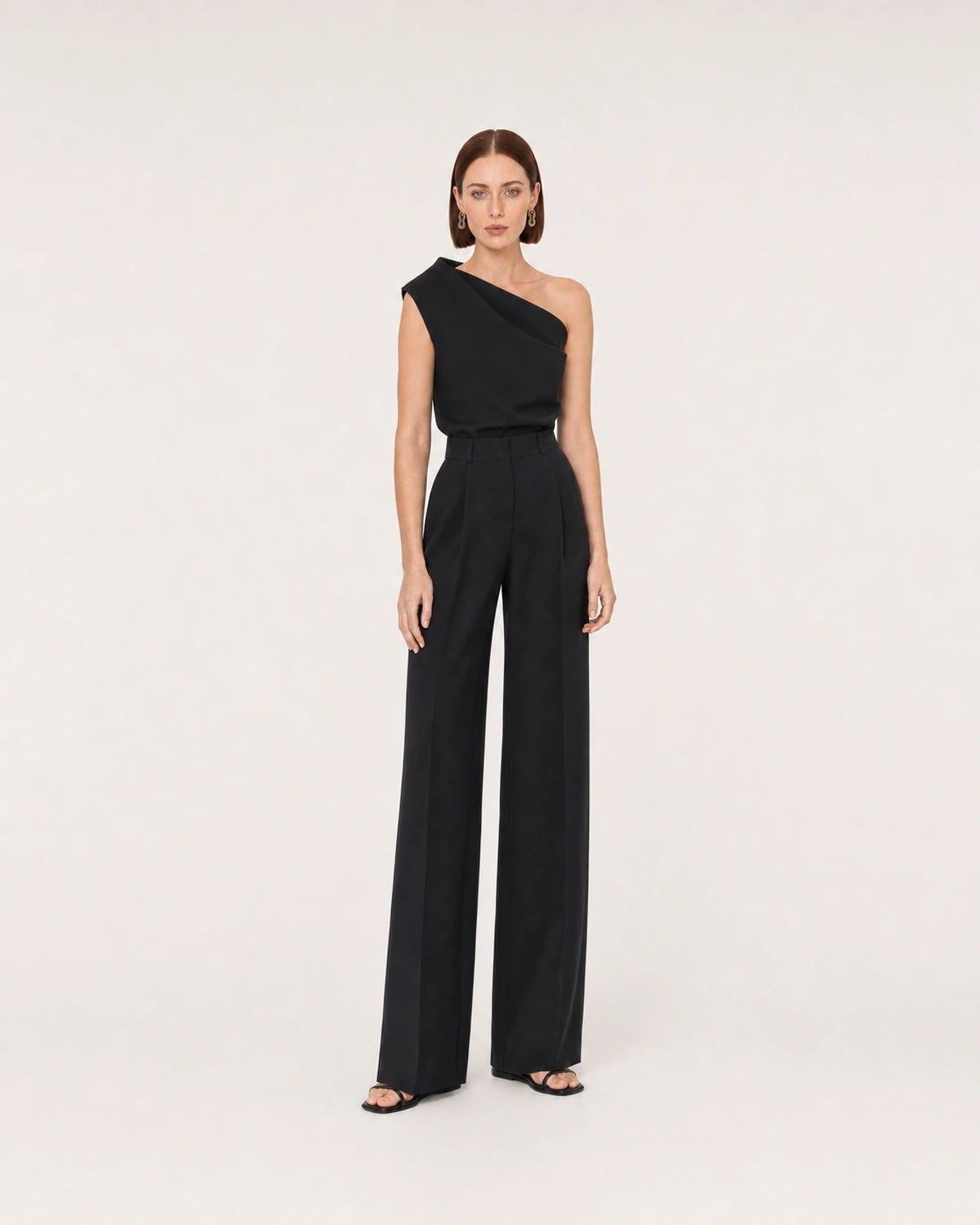 Wide studio portrait in a black one-shoulder look featuring Nysa earrings
