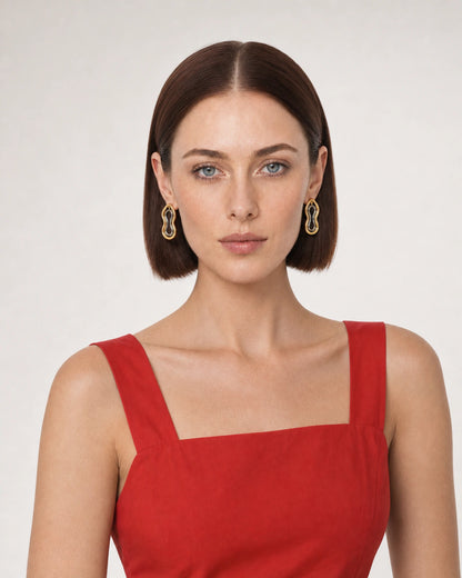 Brunette model in a tomato-red Sicilian summer dress wearing Nysa mixed-metal earrings