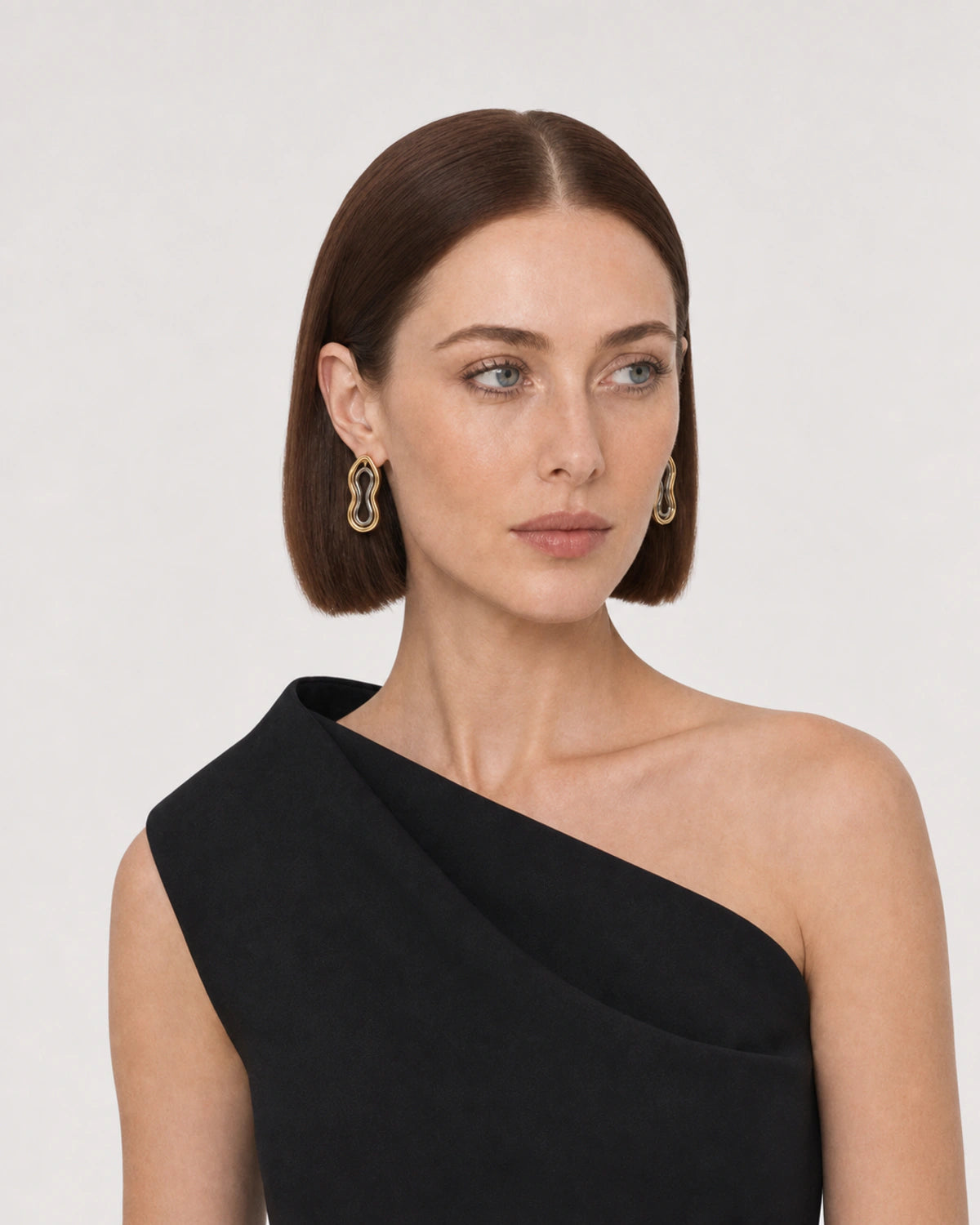 Alternate portrait featuring the Nysa gold and silver sculptural earrings