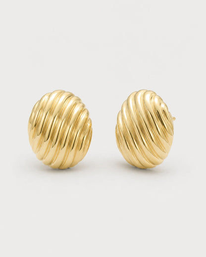 Odette gold ribbed oval stud earrings on pale dove-grey