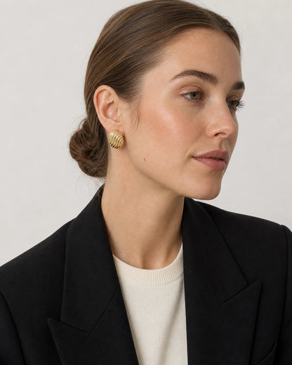 British model wearing the Odette gold ribbed oval stud earrings