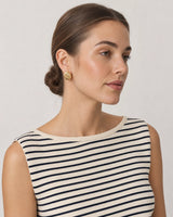Model in a Breton summer knit wearing Odette gold ribbed oval studs