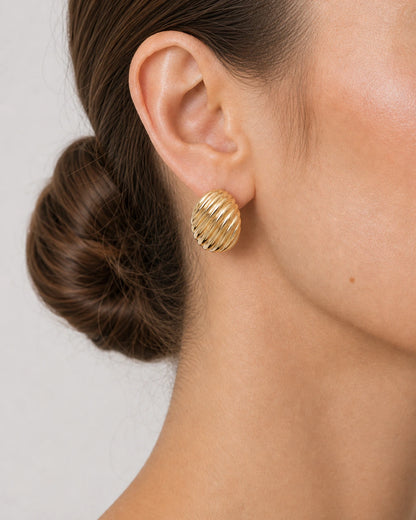 Complete worn macro of the gold Odette oval stud and diagonal ribs