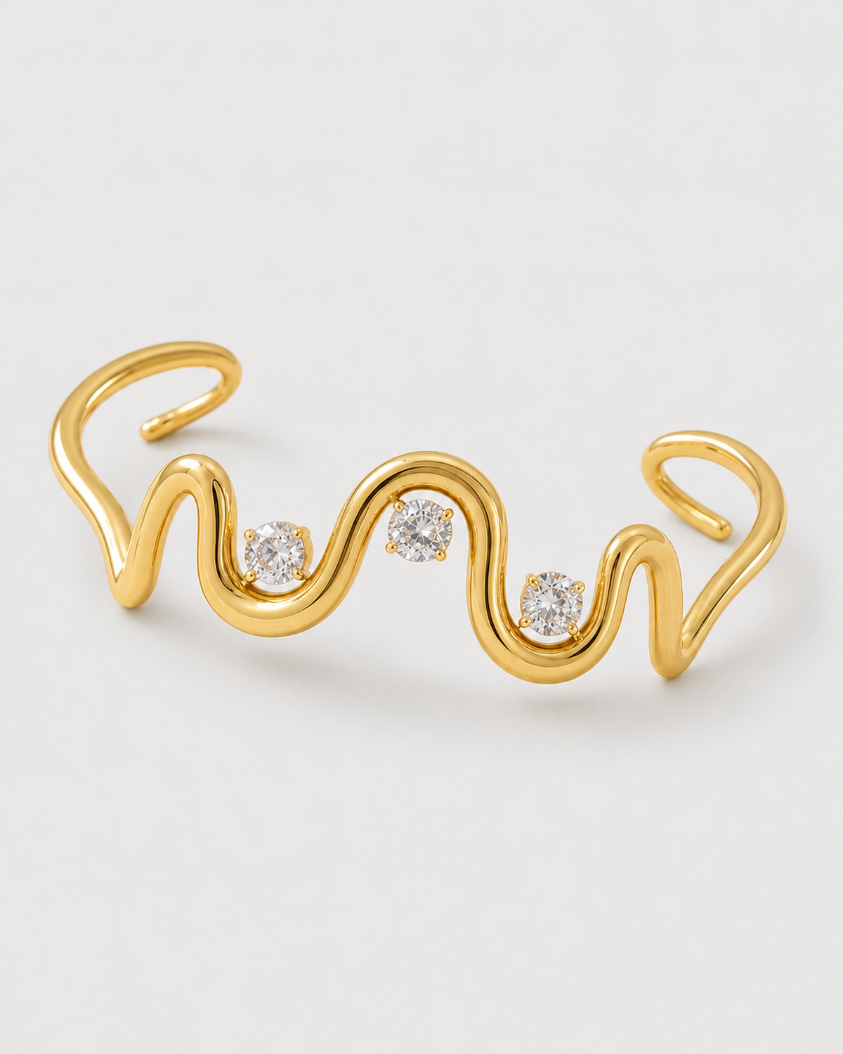 Macro of the Onda sculptural wave cuff and exactly three clear stones