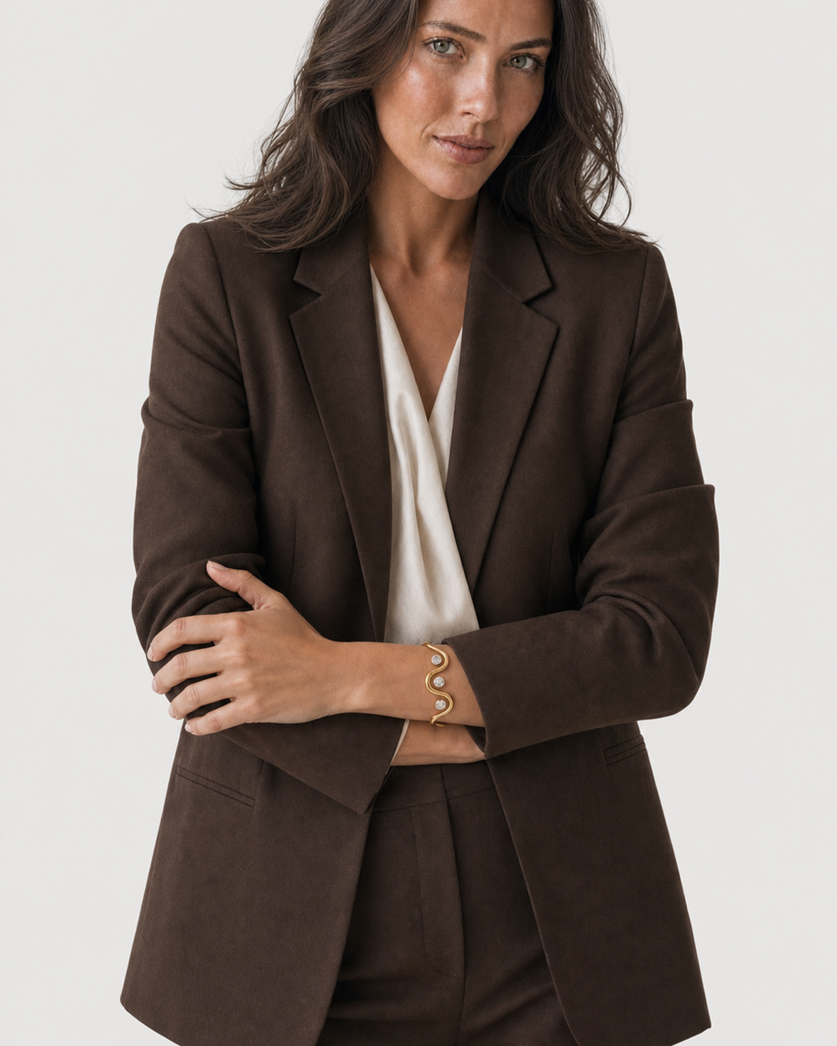 Wide editorial studio portrait showing the Onda three-stone cuff at natural scale
