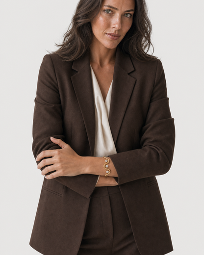 Wide editorial studio portrait showing the Onda three-stone cuff at natural scale