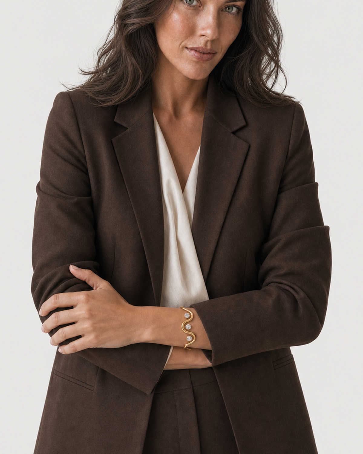 Human-scale view of the Onda crystal wave cuff with chocolate tailoring
