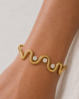 Extreme on-wrist macro of the Onda gold wave and three crystal settings