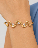 Complete worn macro of the Onda sculptural gold wave, three stones and both cuff shoulders