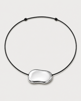 Orra polished silver bean cord necklace on a seamless pale dove-grey studio background