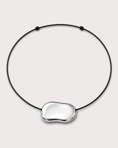 Orra polished silver bean cord necklace on a seamless pale dove-grey studio background