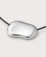 Macro detail of the Orra mirror-polished organic silver bean pendant and black cord