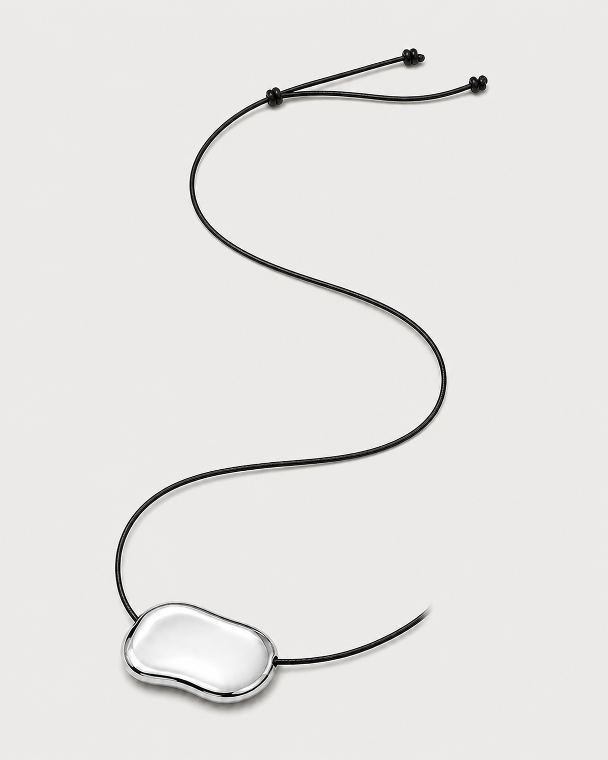 Alternate full-length view of the adjustable Orra black cord necklace on pale dove-grey