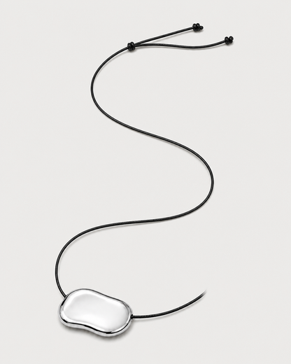 Alternate full-length view of the adjustable Orra black cord necklace on pale dove-grey
