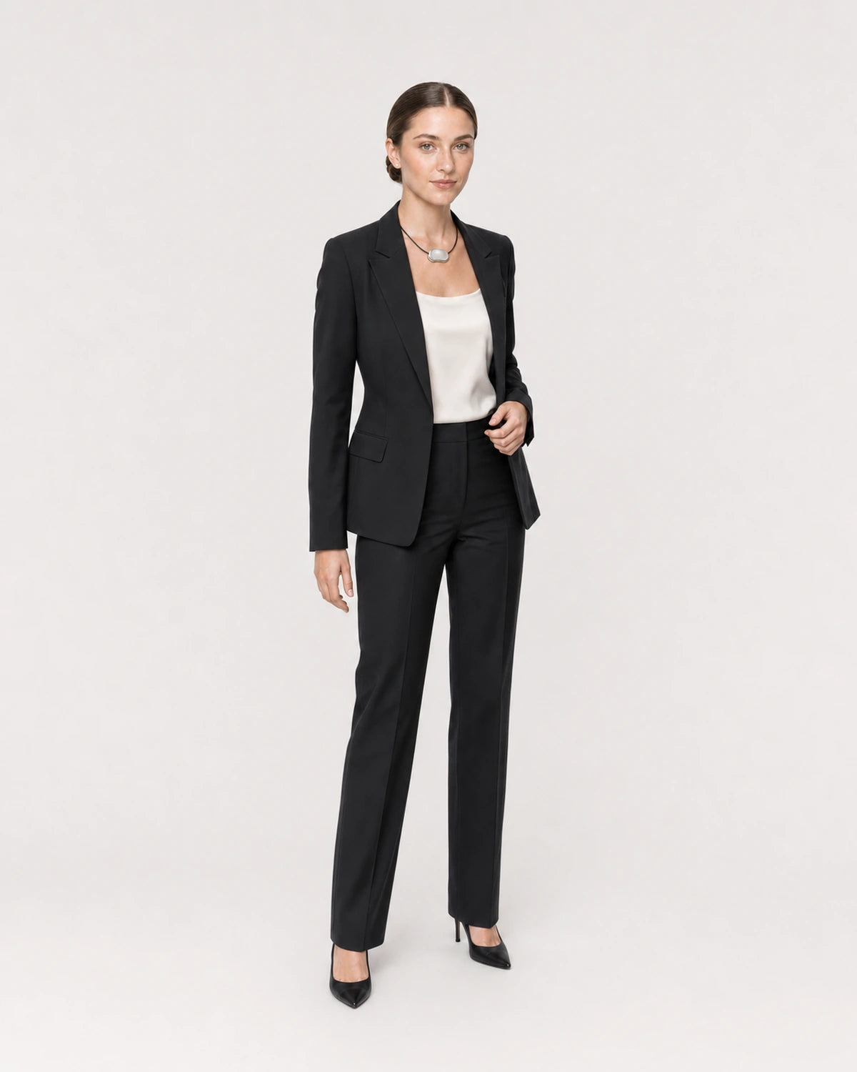 Wide studio portrait showing the Orra necklace with black tailoring at natural scale