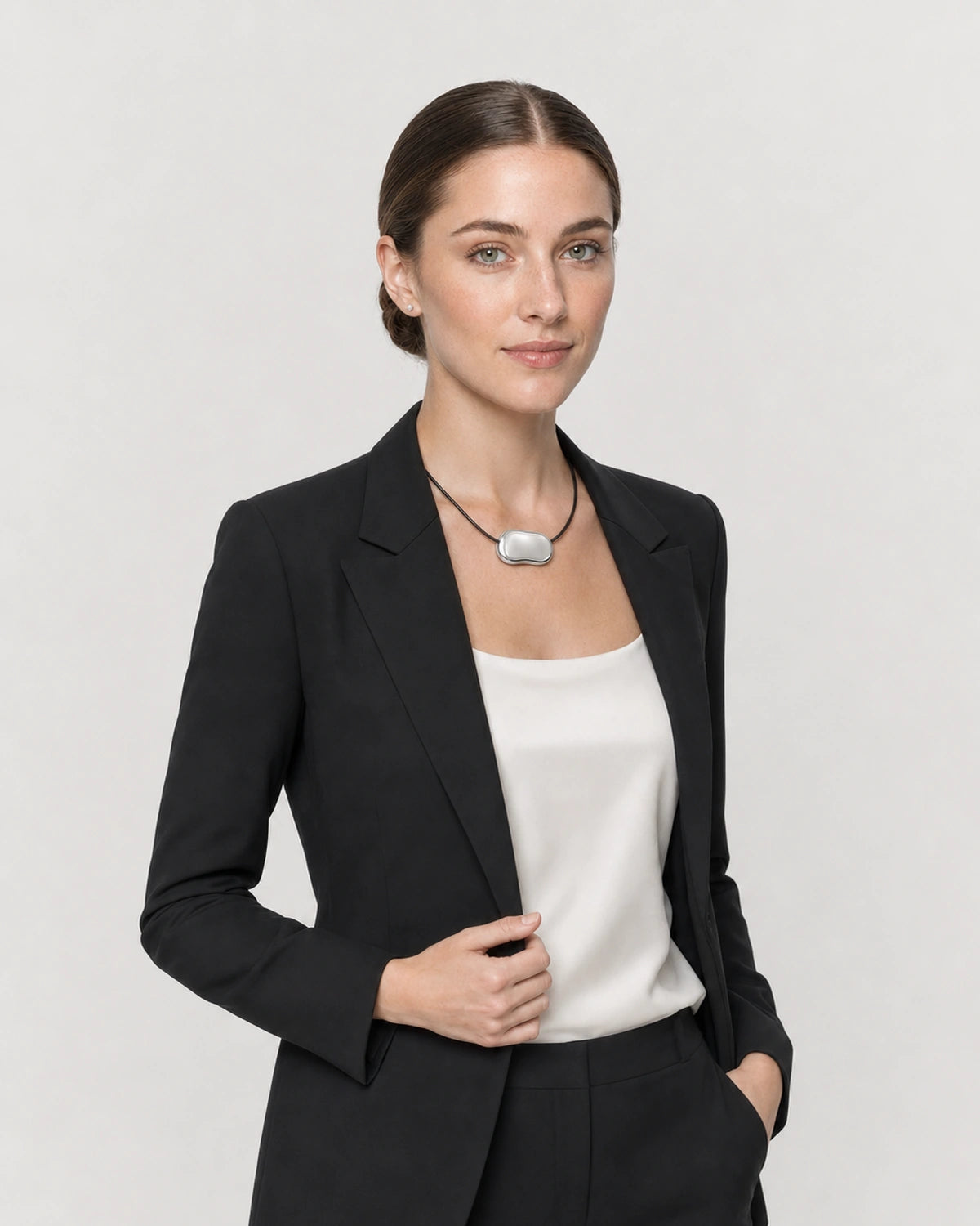 Human-scale studio view of the Orra bean cord necklace worn with black tailoring