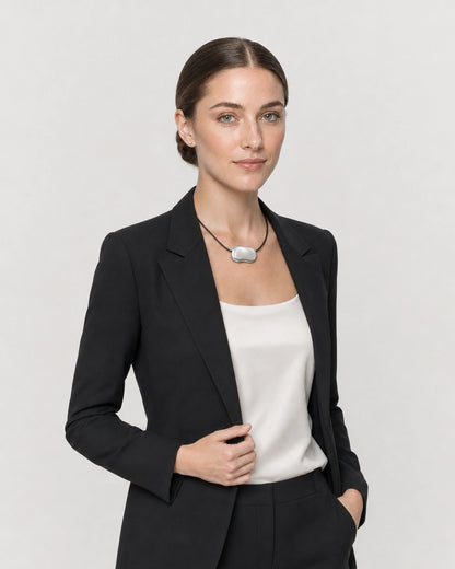 Human-scale studio view of the Orra bean cord necklace worn with black tailoring