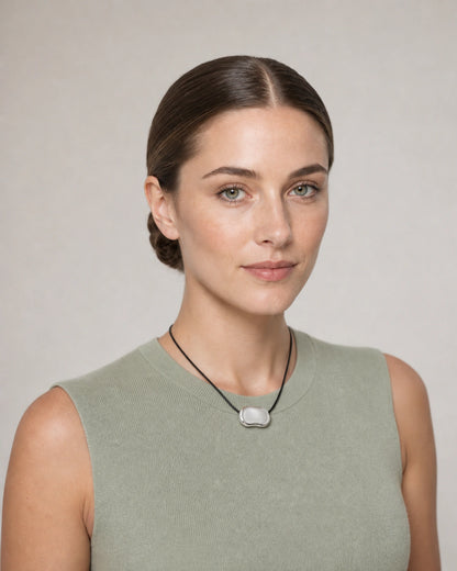 Model in a sage summer knit wearing the Orra silver bean cord necklace