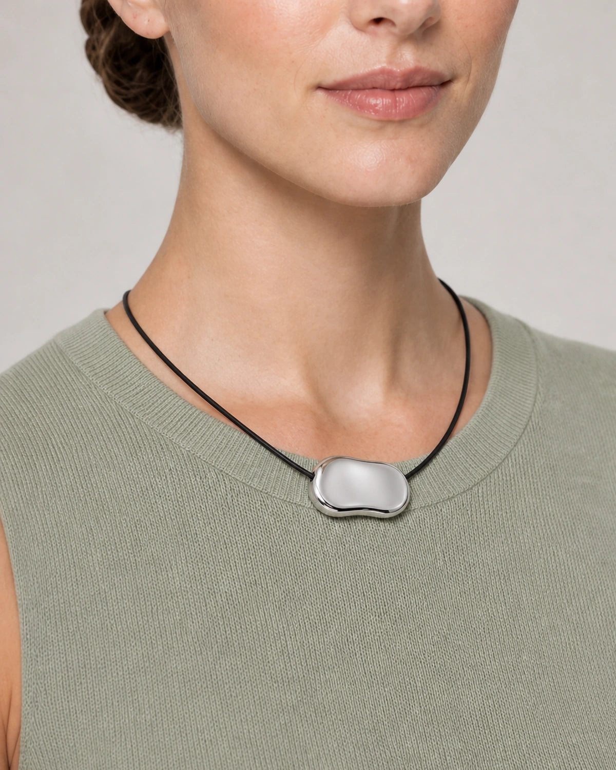 Close wearing view of the Orra mirror-polished silver bean pendant