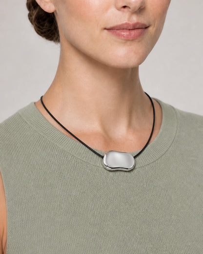 Close wearing view of the Orra mirror-polished silver bean pendant
