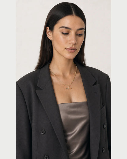Three-quarter portrait of model looking down at the Romy necklace