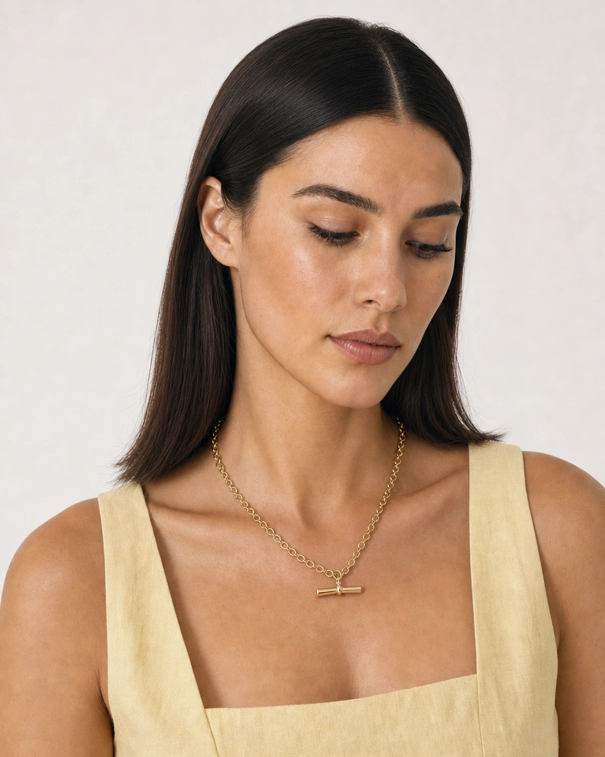 Alternate summer portrait featuring the Romy gold oval-link T-bar necklace