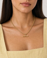 Close wearing view of the Romy gold oval-link chain and sculpted T-bar