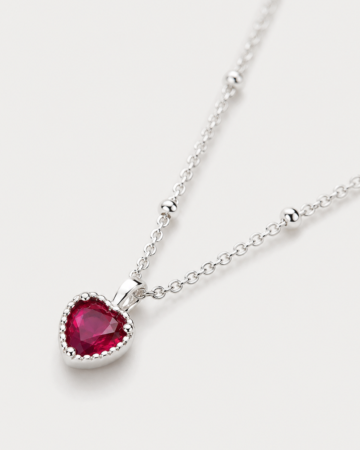 Macro view of the Rosalie ruby-red heart and silver beaded chain