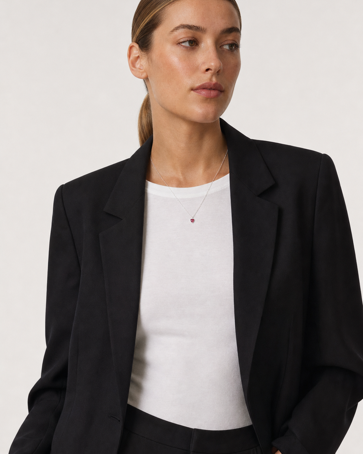 Wide grey-studio portrait featuring the Rosalie red heart necklace