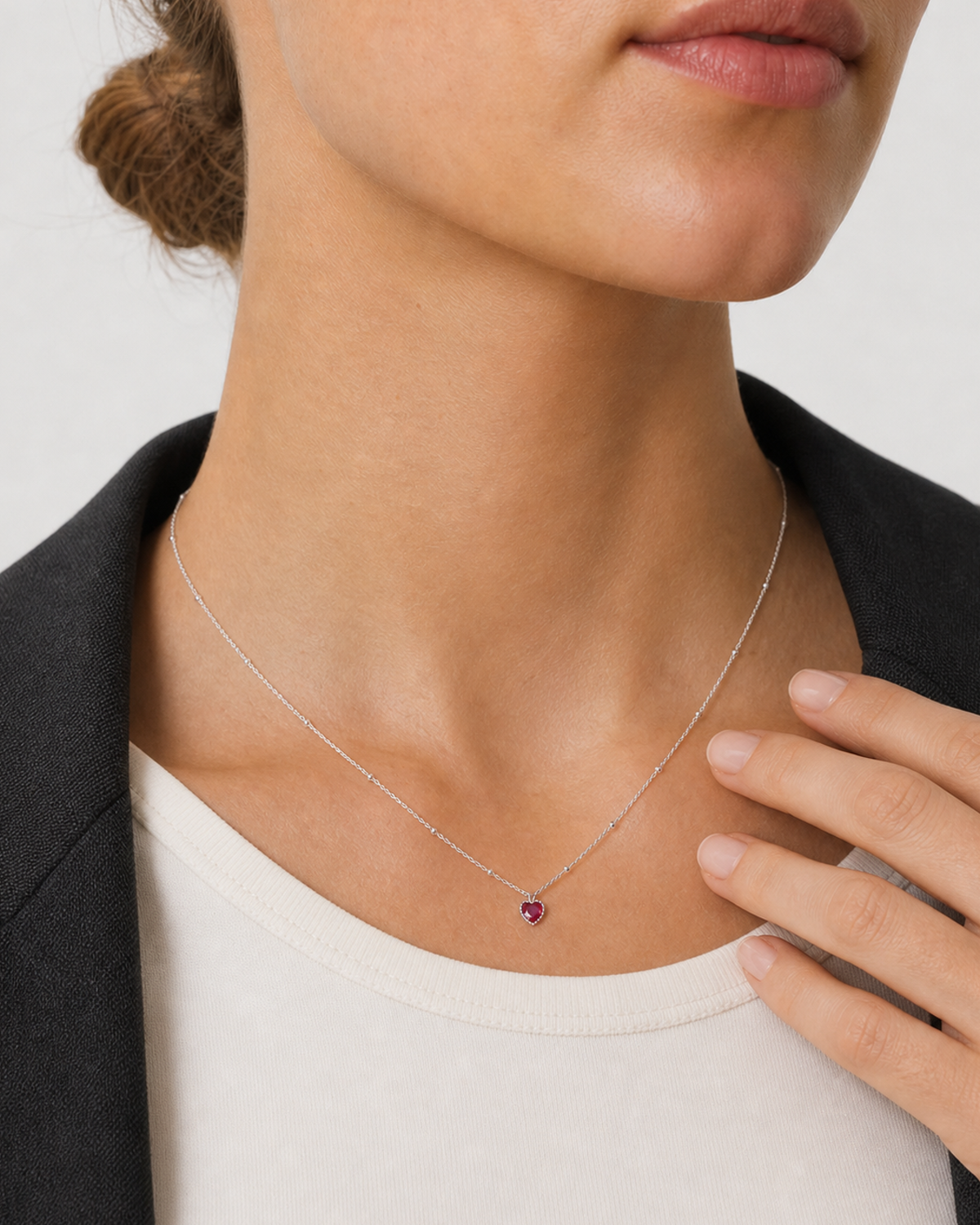 Human-scale wearing detail of the petite Rosalie red heart pendant