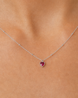 Extreme on-body macro of the Rosalie ruby-red heart and beaded chain