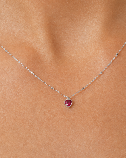 Extreme on-body macro of the Rosalie ruby-red heart and beaded chain