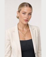 Three-quarter studio portrait featuring the Sabine gold T-bar necklace