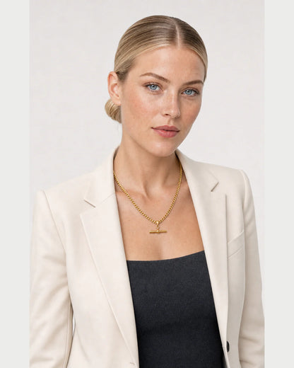 Three-quarter studio portrait featuring the Sabine gold T-bar necklace
