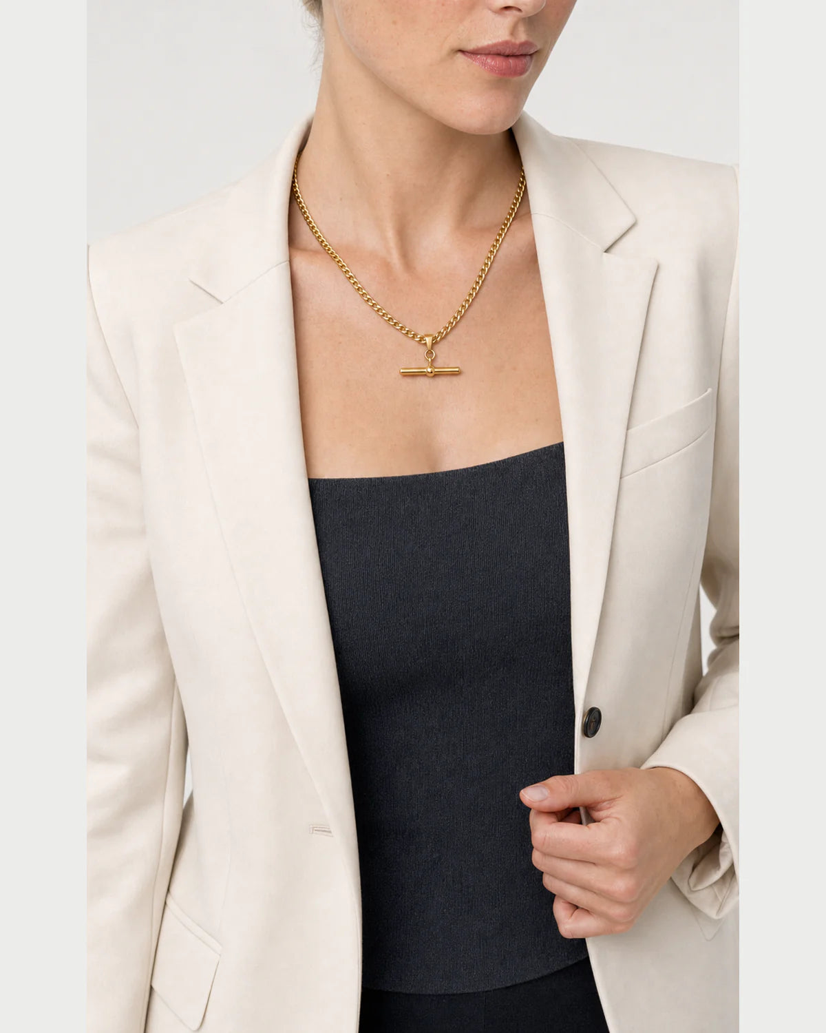 Model holding her blazer lapel while wearing the Sabine curb necklace