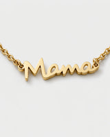 Macro detail of the polished connected Mama script and fine gold chain