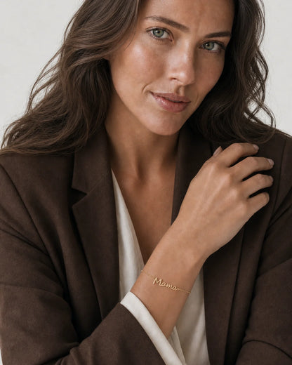 Australian model aged 25 to 28 wearing the Sera Script Mama Bracelet in a pale dove-grey studio